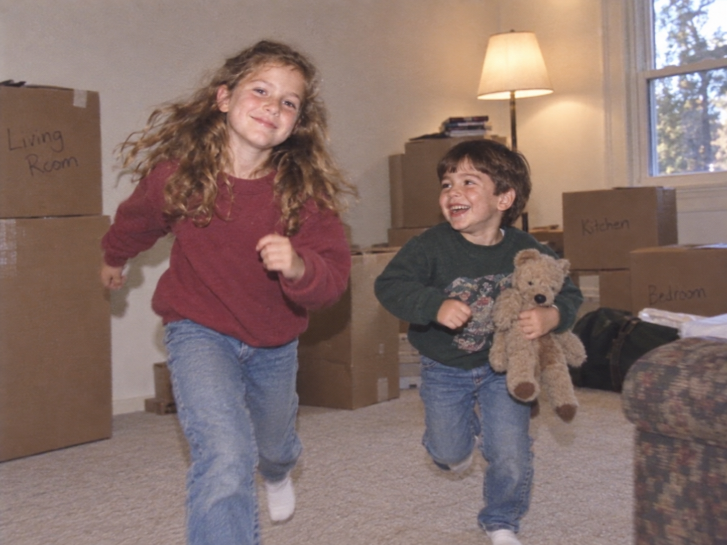A home-video frame of Rachel and Daniel among moving boxes.
